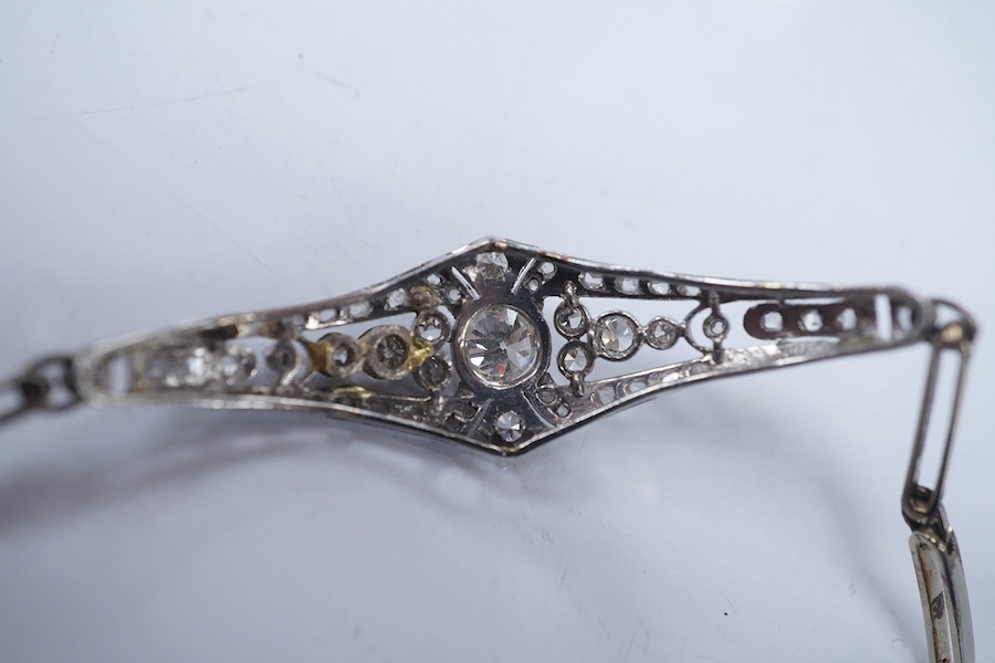 An early 20th century pierced gold, platinum and diamond set bracelet, the central motif set with round, eight and rose cut stones, 18cm, gross weight 8.9 grams. Condition - fair to good